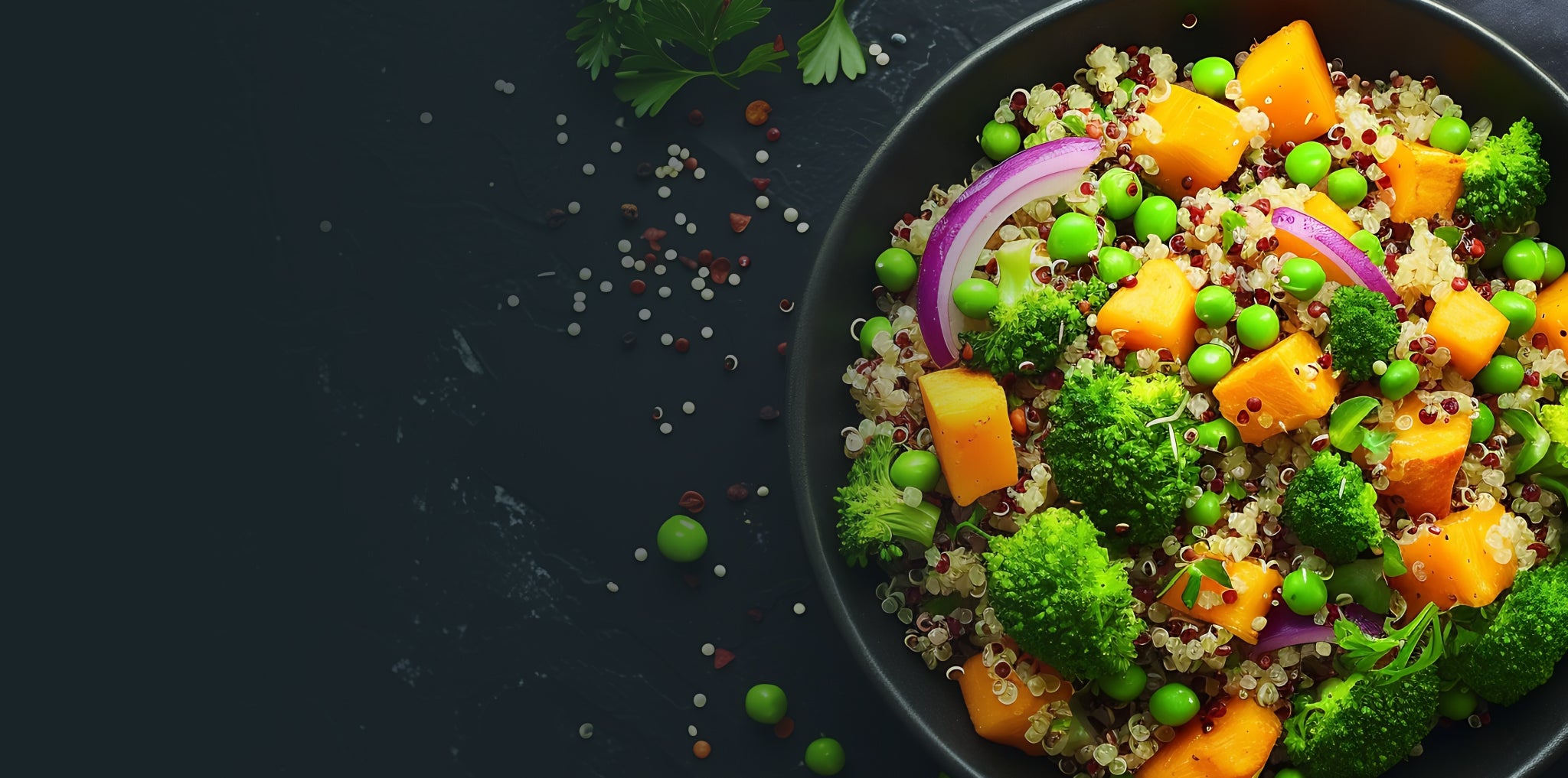 A bowl of quinoa and brightly colored vegetables on a dark background.