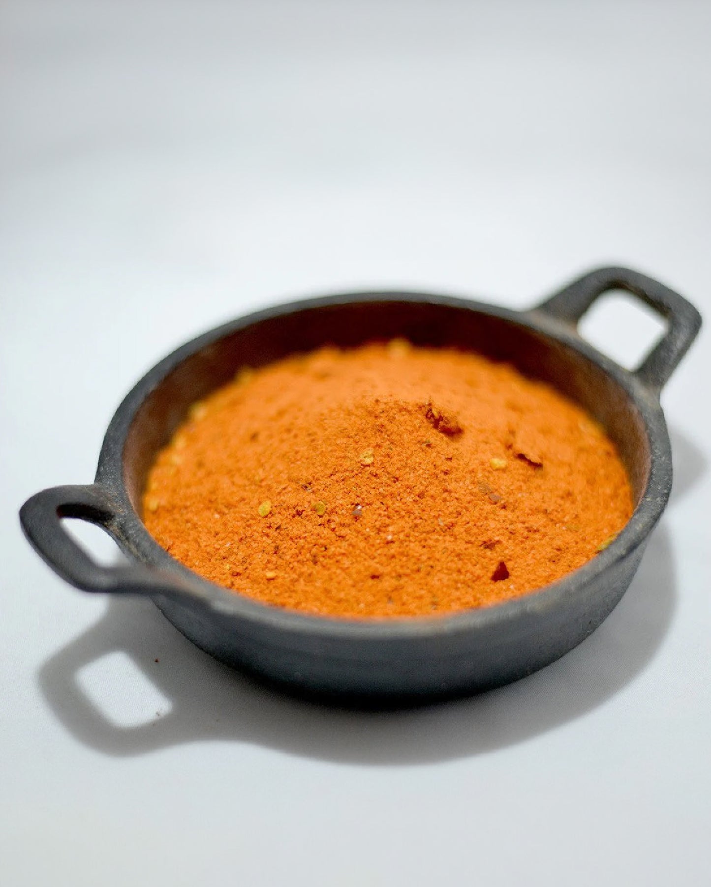 Close-up picture of Hickory Stix seasoning in a mini cast iron pan.